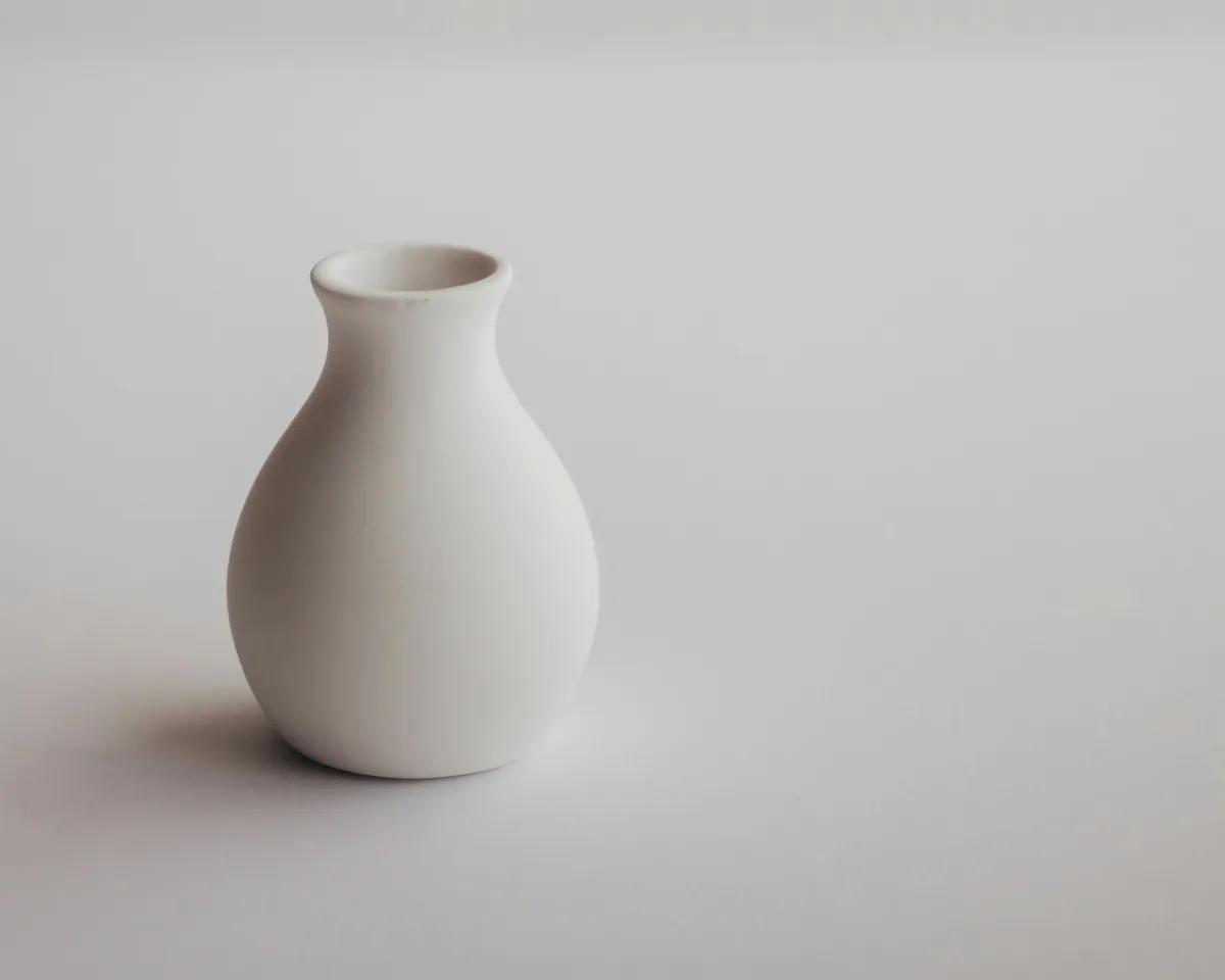 White ceramic vase on a light grey background
