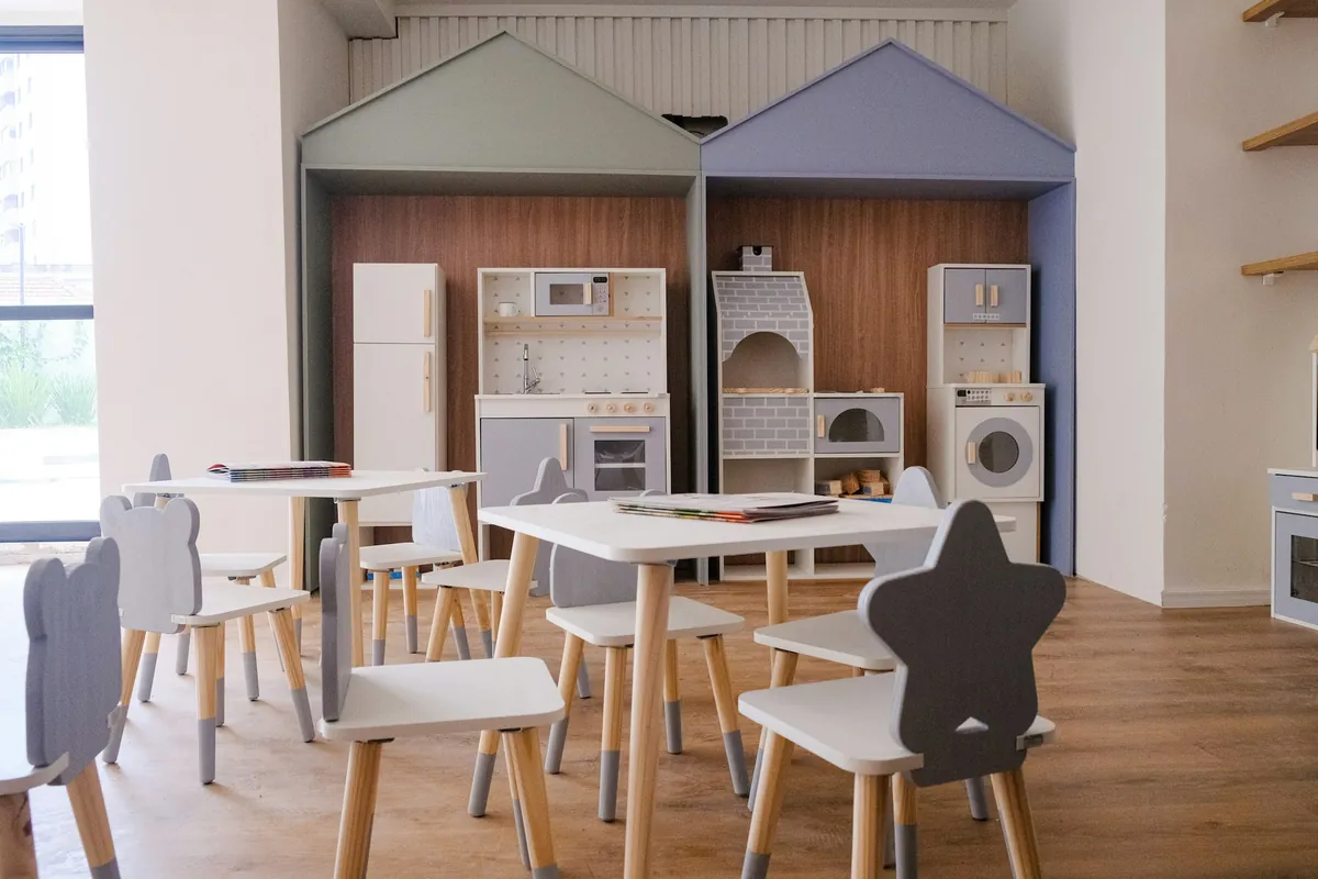 Bright children's room with small tables, chairs and a play kitchen