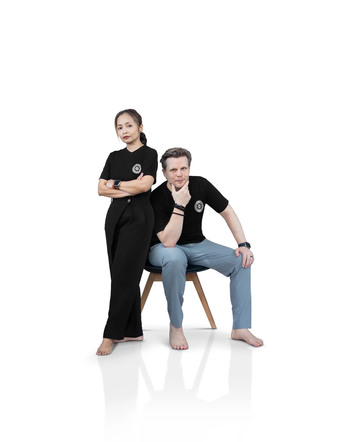 Vita und Frank Balgar in schwarzen Shirts, sie steht, er sitzt auf einem Stuhl, vor weissem Hintergrund
